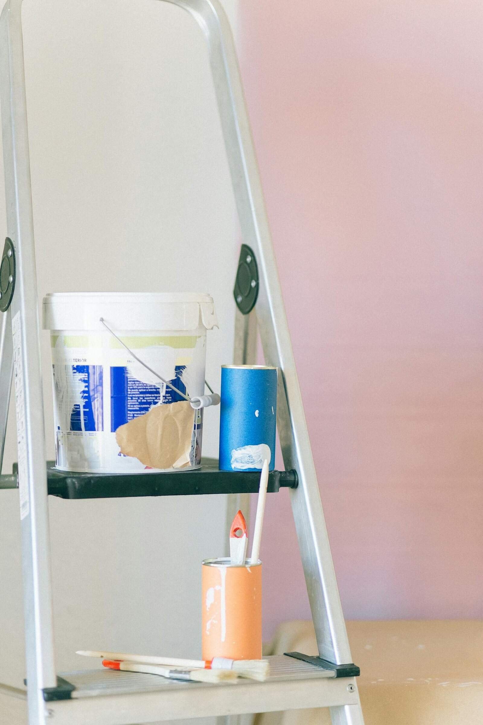 A ladder with painting tools and materials used for home renovation and interior design.