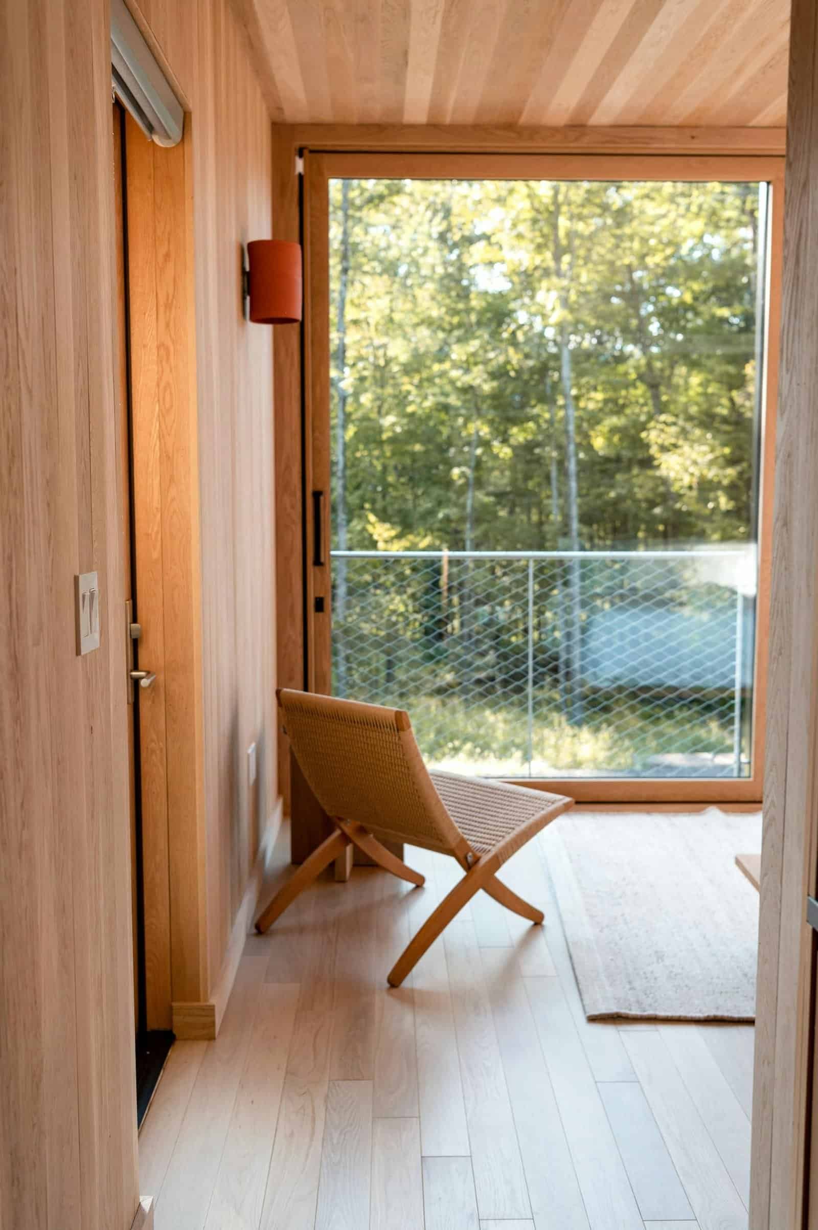 A peaceful interior featuring natural wood and a sunlit view of lush greenery.
