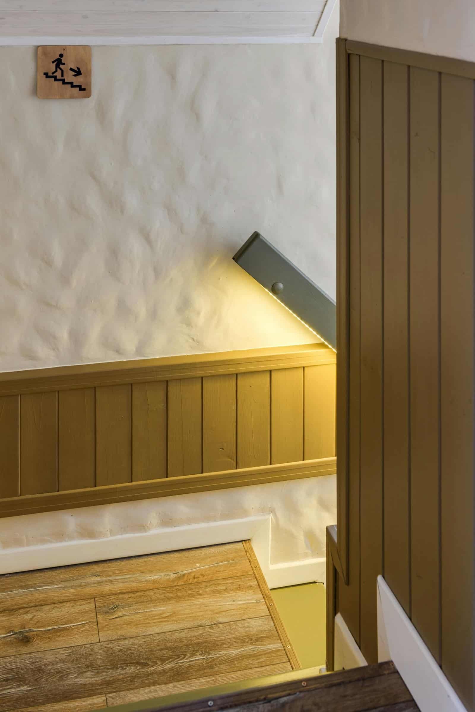 Elegant minimalist staircase with wooden panelling and soft lighting.