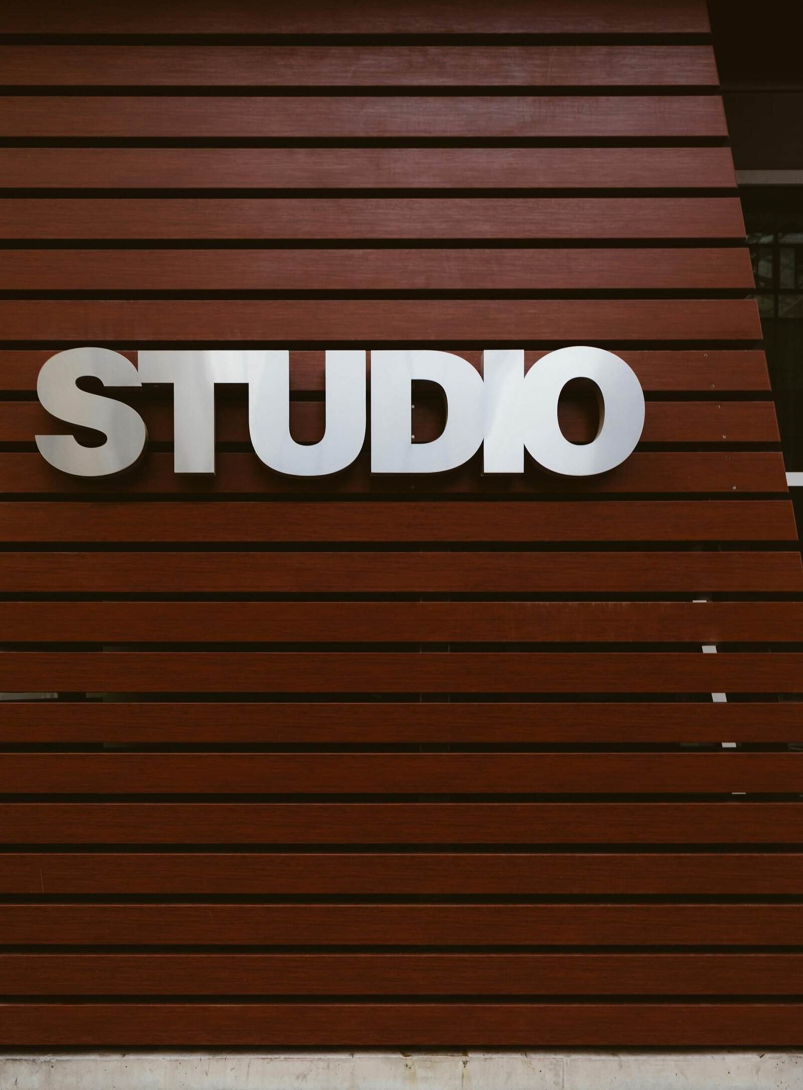 Sleek studio sign on a modern wooden panel exterior wall, perfect for design and architecture themes.